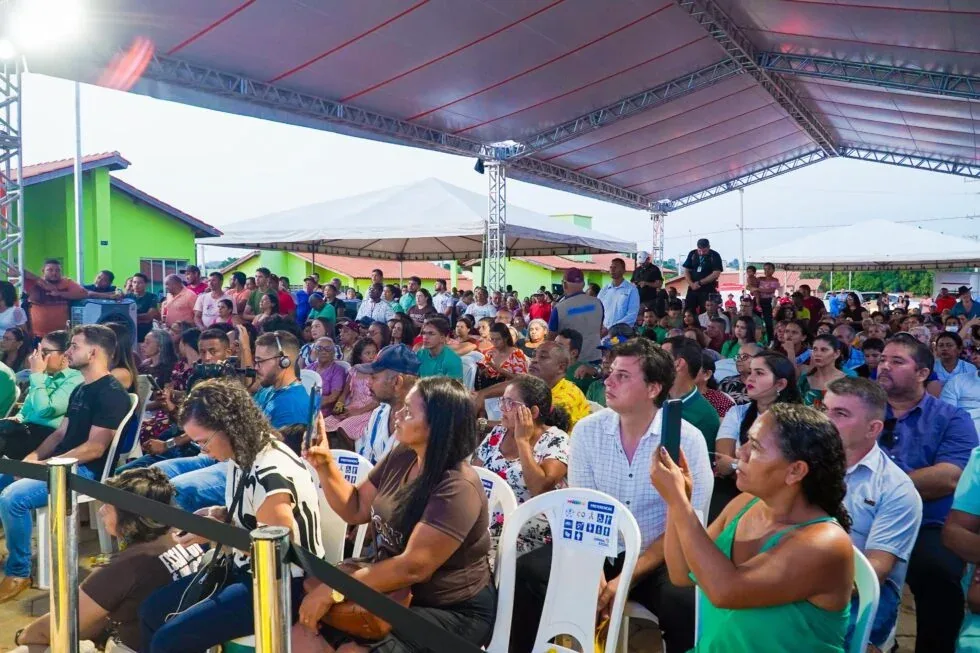 Solenidade de abertura da entrega das chaves em Piquiá da Conquista (25/10/2024). Ana Maria, de verde, aparece no canto segurando um celular